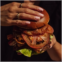 Bij onze Oaklahoma smashburger verwerken wij fijngesneden uien direct door het gehakt voor extra smaak en subtiele zoetheid. Dubbele beef patty's, rijkelijk belegd met English cheddar, huisgemaakte gefrituurde uienringen en huisgemaakte BBQ saus.<br>Tip: Nog lekkerder met bacon!